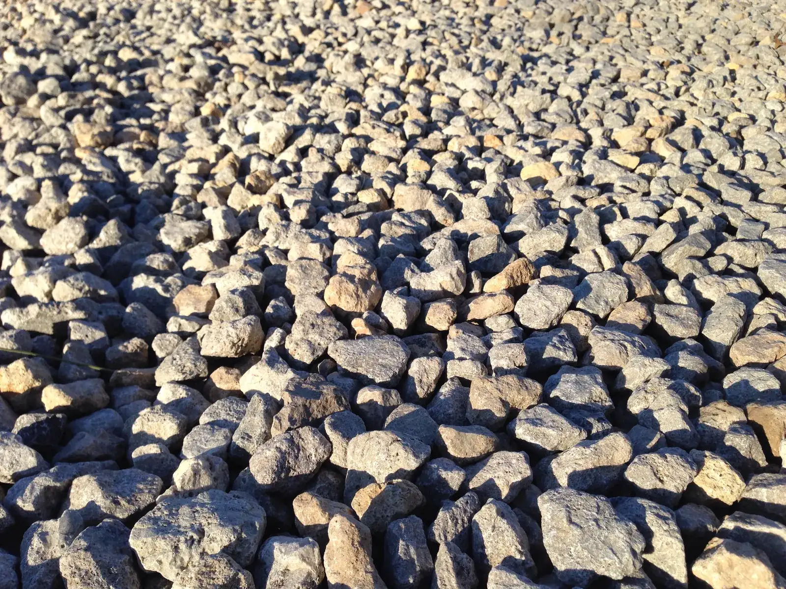 Close view of angular crushed rock on the surface of a gravel driveway